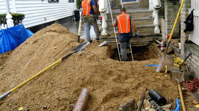 Contractors performing foundation protection and exterior drainage excavation near residential home steps in Charleston, SC